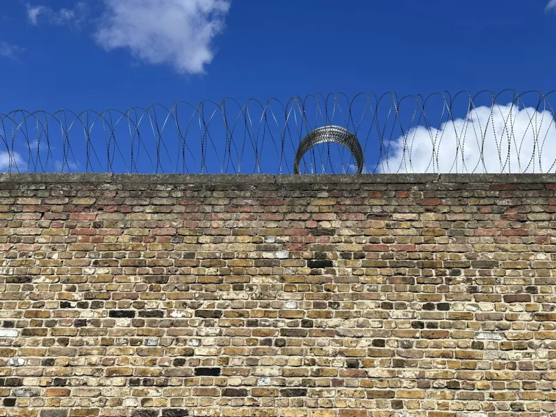 Perimeter wall with security topping